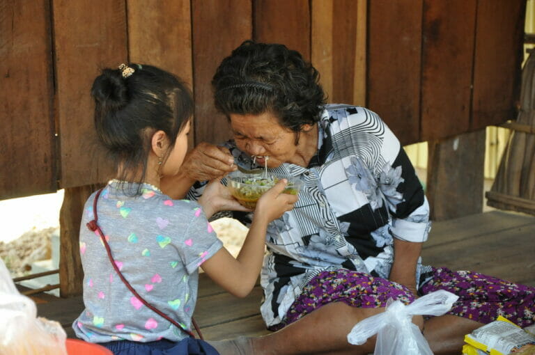 Sreykeo helping to feed one of the elderly - Cambodia